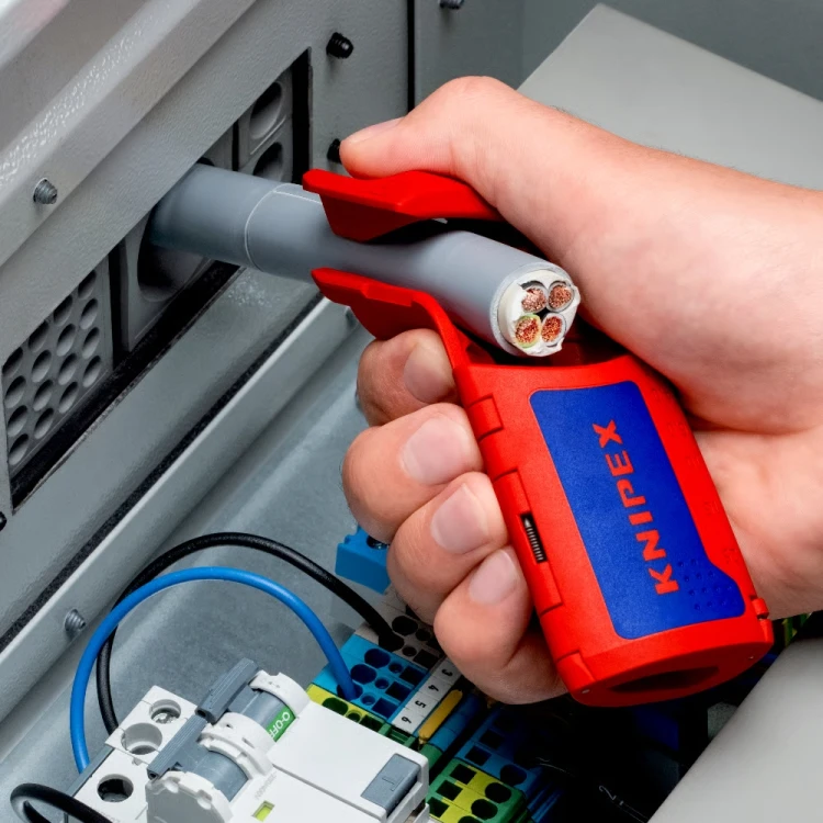 KNIPEX 16 95 11 ErgoStrip XL podczas przygotowywania wielożyłowego kabla zasilającego w rozdzielnicy elektrycznej – praca przy ograniczonej przestrzeni montażowej.