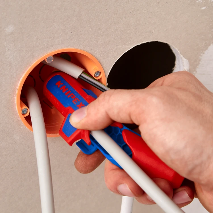 KNIPEX ErgoStrip PV podczas przygotowywania kabla okrągłego w puszce podtynkowej – kompaktowe narzędzie do zdejmowania płaszcza w ograniczonej przestrzeni.